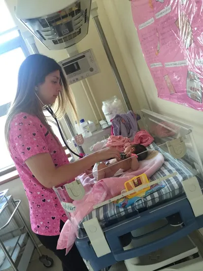 La doctora auscultando a una recién nacida en una cuna
